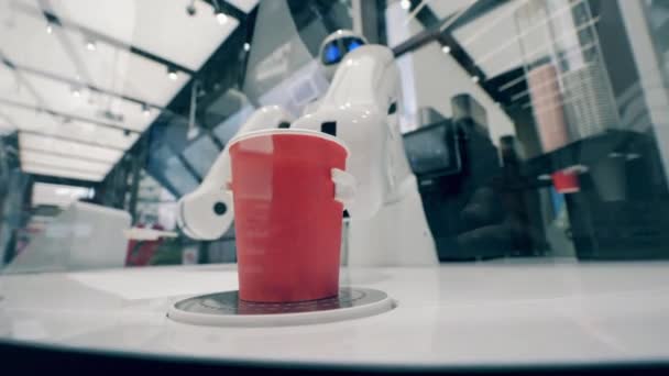 Cyborg staví šálek kávy na stůl. — Stock video