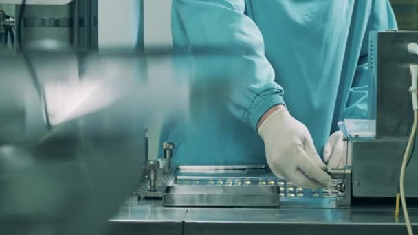 Production de médicaments dans une usine de production pharmaceutique. Travailleur d'usine gère un convoyeur avec des pilules capsule — Video