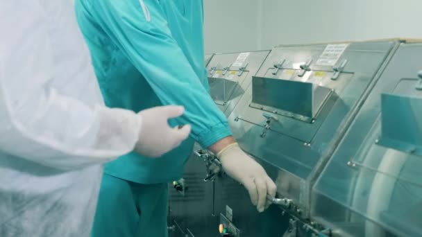 Gyógyszerészeti dolgozók nyitják meg a gyári gépet. — Stock videók