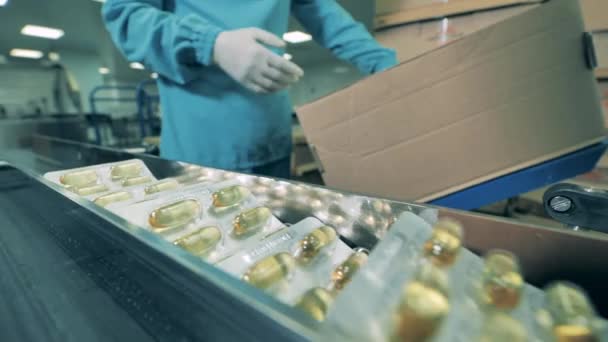 Um especialista está empacotando bolhas de cápsulas médicas. Empresa farmacêutica produz antivírus. — Vídeo de Stock