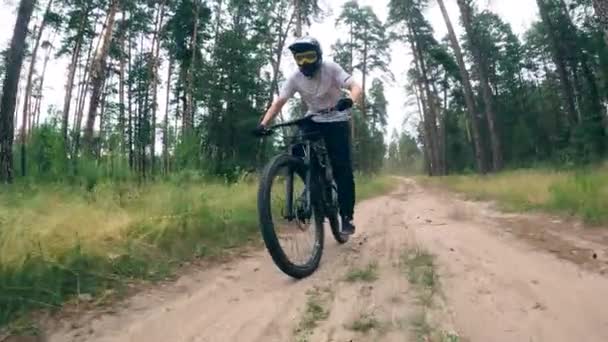 Trilha florestal e um atleta masculino montando uma bicicleta esportiva — Vídeo de Stock