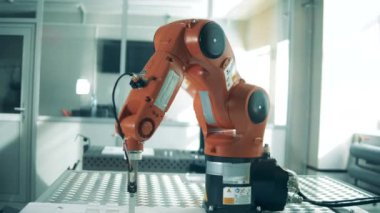 Metal robot kolu fabrikada çalışıyor..