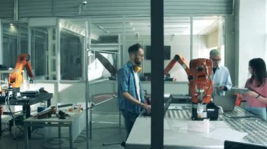 Bir kadın ve bir erkek robot cihazın çalıştığını kontrol ediyor. Yenilik, yüksek teknoloji eğitimi, bilim eğitimi kavramı.