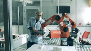 Laboratuvarda laptop kullanan bir kişi otomatik kolu kontrol ediyor..