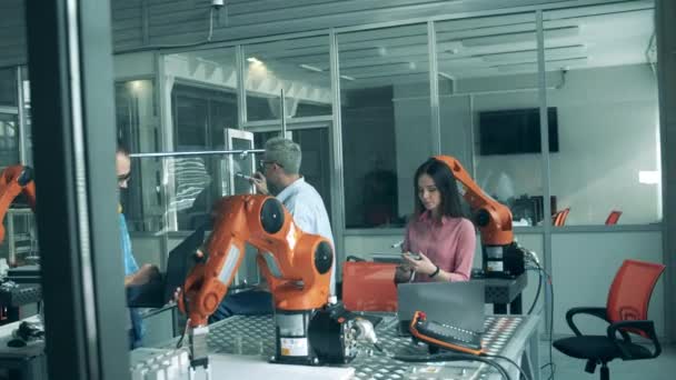 Modern bilim laboratuarı. Mühendisler laboratuvarda robot kolla çalışıyorlar.. — Stok video