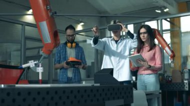 Yenilik, yüksek teknoloji eğitimi, bilim eğitimi kavramı. İnsanlar robotik kolu kontrol etmek için VR gözlükleri kullanıyor.