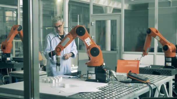 One man checks working robotic arm on a table. Modern science laboratory. — Stock Video