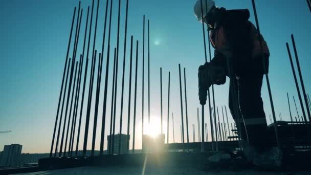 Um trabalhador está usando um martelo pneumático para esmagar cimento — Vídeo de Stock