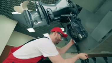Servis mühendisi bir motorun motorunu tamir ediyor.