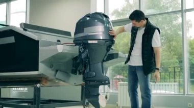 Erkek alıcı yelkenli motorunu inceliyor.
