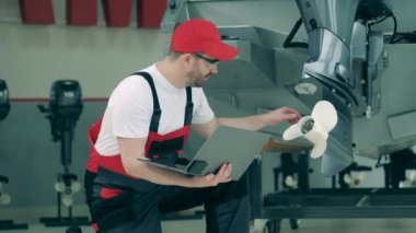 Görevli motorun pervanesini kontrol ediyor.