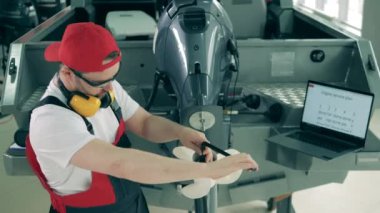 Görevli motorlu tekne pervanesini tamir ediyor.