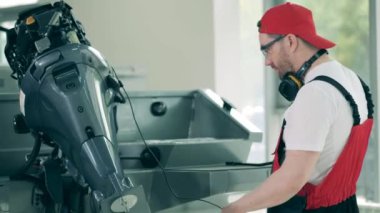 Teknisyen bir tekneyi kontrol edip tamir ediyor.