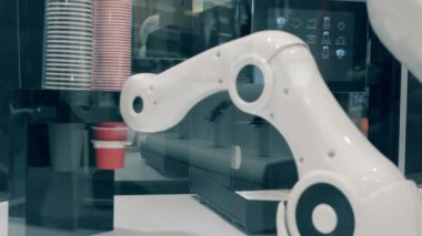Robotun kolu bir kahve bardağının yerini değiştirip dolduruyor. Gelecekçi robot, yenilikçi teknoloji kavramı.