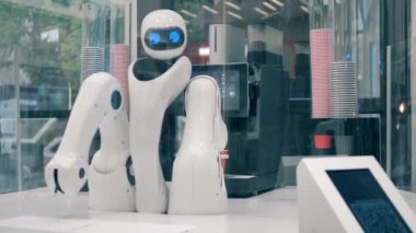 Yenilik, modern teknoloji konsepti. Sibernetik garson bir bardağı kahveyle dolduruyor.