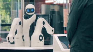 Yenilik, modern teknoloji konsepti. Bir müşteriye kahve dükkanında droid servis ediliyor.