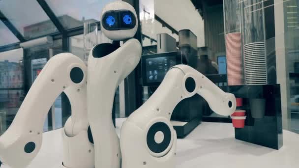 Robot futurista, concepto tecnológico innovador. Droid está tomando una taza de papel y moviéndola a una máquina de café. — Vídeo de stock