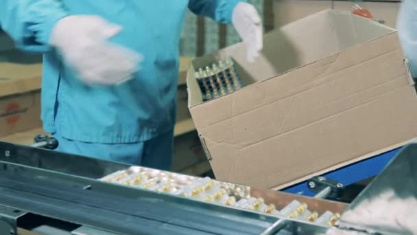 Farmakologen lägger droger i blåsor i en kartong. — Stockvideo