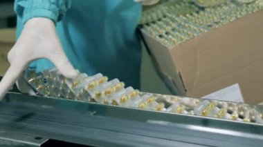 İlaç uzmanı konveyörden su toplayan hapları kaldırıyor. Eczacılık, eczane konsepti.
