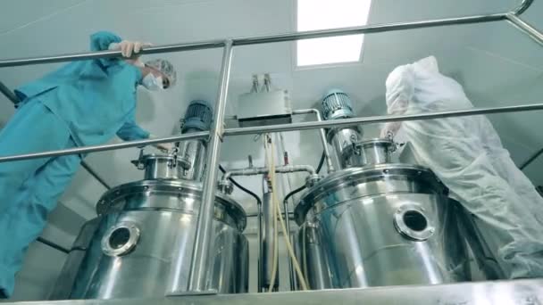 A gyógyszeripari dolgozók kezelik az erjesztő reaktorokat. — Stock videók