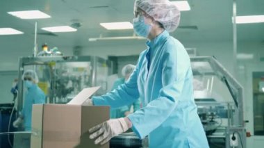 İlaç işçisi kutuları tıbbi ürünlerle dolduruyor.