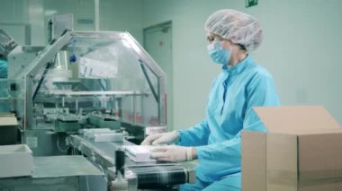 Kadın eczacı kutuları ilaçla dolduruyor.