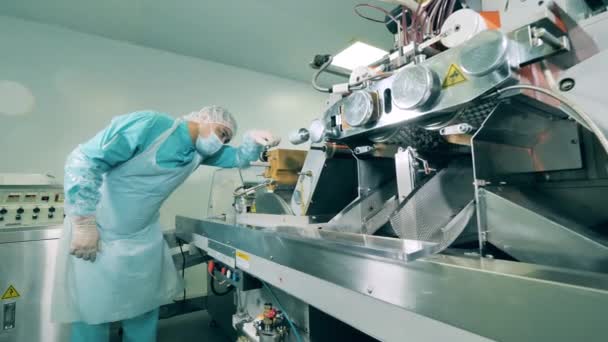 Männlicher Experte überprüft eine Fördermaschine, die Pillen transportiert — Stockvideo