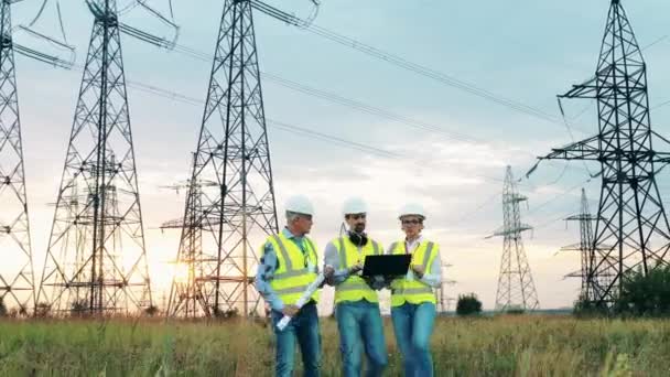 İşçiler tarladaki elektrik santrallerini kontrol ediyor. — Stok video