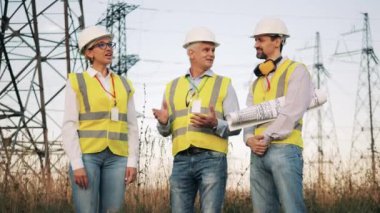 Profesyonel mühendisler güç şebekeleri olan bir alanda konuşurken konuşuyorlar. Elektrik endüstrisi, elektrik enerjisi üretim konsepti.