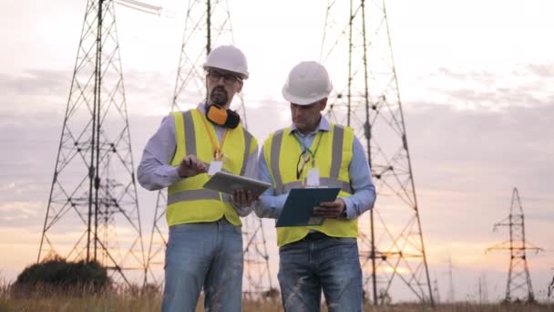 Werknemers controleren stroomleidingen in het veld. — Stockvideo