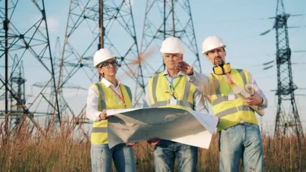 Inżynierowie sprawdzają plan podczas pracy z liniami energetycznymi. — Wideo stockowe