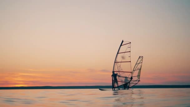Män på vindsurfingbrädor hanterar segel medan de flyter — Stockvideo