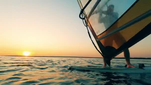 Un hombre está cayendo de la tabla de windsurf y dejando caer la vela — Vídeos de Stock