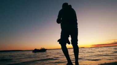 Bir çocuk göl kenarında bir baba tarafından döndürüldü.