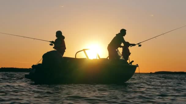 Un padre pesca con i suoi figli al tramonto — Video Stock