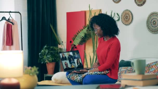 Mujer africana está hablando con varias personas a través de computadora portátil durante el encierro — Vídeo de stock