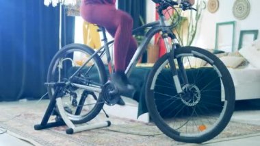 Bisiklet alıştırma makinesi Afrikalı bir kadın tarafından kullanılıyor.