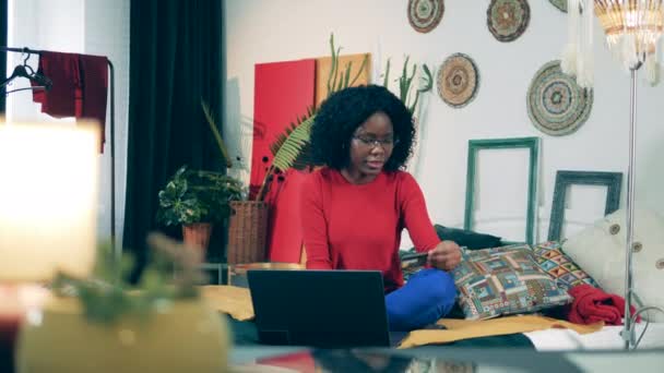 युवा आफ्रिकन महिला स्वत: ची क्वारंटाइनमध्ये ऑनलाइन खरेदी करत आहे — स्टॉक व्हिडिओ