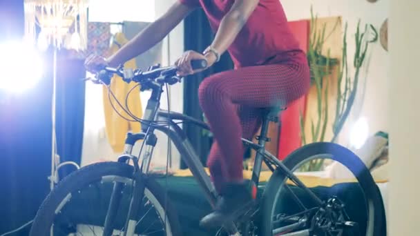 African lady is riding a mechanical bicycle in self-quarantine — Stock Video