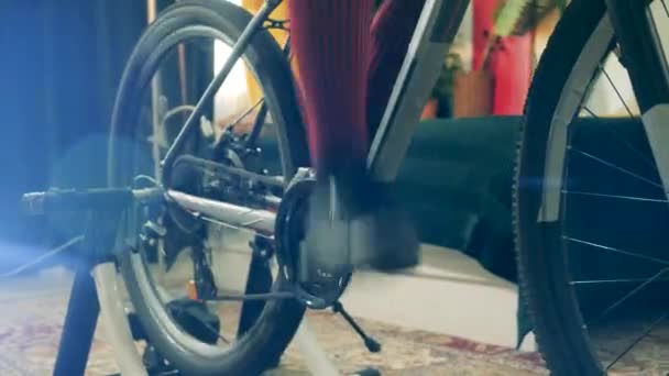 한 부인이 집에서 자전거 페달을 밟고 있다 — 비디오