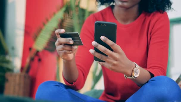 Un smartphone y una tarjeta en manos de una mujer africana — Vídeos de Stock