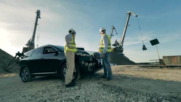 Specialister pratar nära en bil i industrianläggningen. — Stockvideo