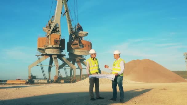 Cantera de arena con cargadores industriales y dos ingenieros hablando — Vídeo de stock