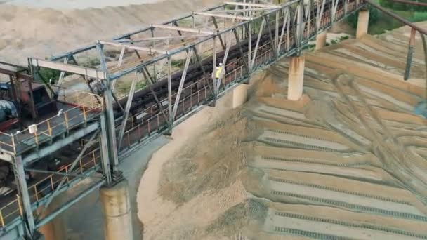 Специалисты идут по мосту в песчаном карьере — стоковое видео