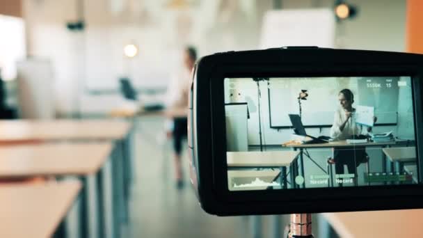 Uma mulher a ter uma aula online está a ser filmada na sala de aula vazia. Classe on-line, conceito de estudo remoto. — Vídeo de Stock