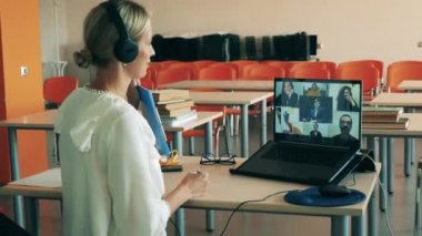 Bir kadın sanal derste birden fazla kullanıcıyla konuşuyor. Uzaktan eğitim, online üniversite dersi, uzak öğrenim konsepti.