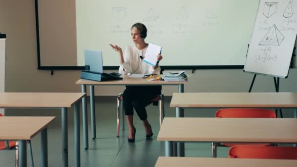 Professora está tendo uma aula virtual na aula vazia — Vídeo de Stock