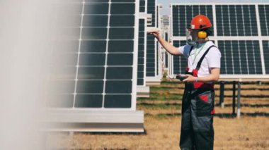 Mühendis güneş panellerindeki gerilimi ölçüyor.