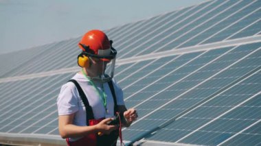 Güneş panellerindeki gerginlik bir tamirci tarafından kontrol ediliyor. Yenilenebilir enerji, güneş santrali, yeşil elektrik kavramı.