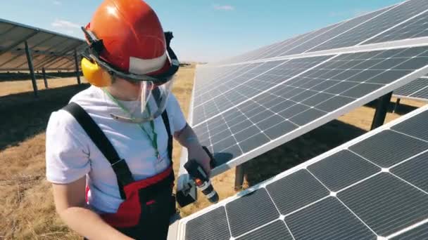 O homem da manutenção está a trabalhar com baterias solares. Trabalhador da energia alternativa perto da central de energia solar. — Vídeo de Stock